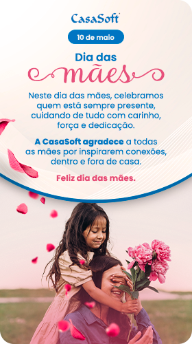 Card comemorativo de Dia das Mães da CasaSoft. À esquerda, o texto 'Dia das Mães - 10 de maio' seguido pela mensagem: 'Neste dia das mães, celebramos quem está sempre presente, cuidando de tudo com carinho, força e dedicação. A CasaSoft agradece a todas as mães por inspirarem conexões, dentro e fora de casa. Feliz dia das mães.' À direita, uma foto de uma menina cobrindo os olhos da mãe em um jardim, com pétalas de flores rosas caindo ao redor delas.